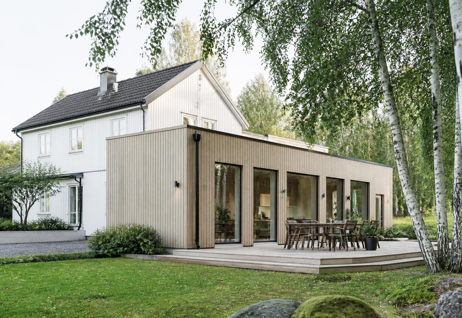 Modern svensk villa med ny tillbyggnad i trä och stora fönster